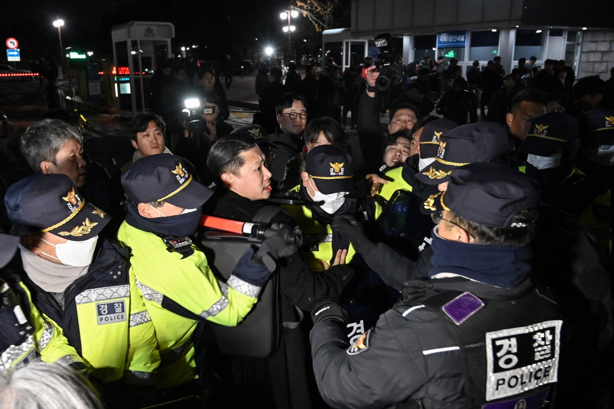 Police attempt to hold back people trying to enter the National Assembly in front of the main gate of the National Assembly in Seoul, South Korea on December 3, 2024, after President Yoon Suk Yeol declared emergency martial law. Jung Yeon-je, AFP
